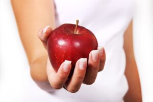 Weibliche Hand mit rotem Apfel Iris Jahns