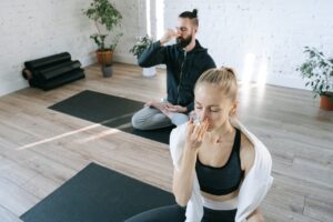 Mann und Frau sitzen entspannt beim Yoga Iris Jahns